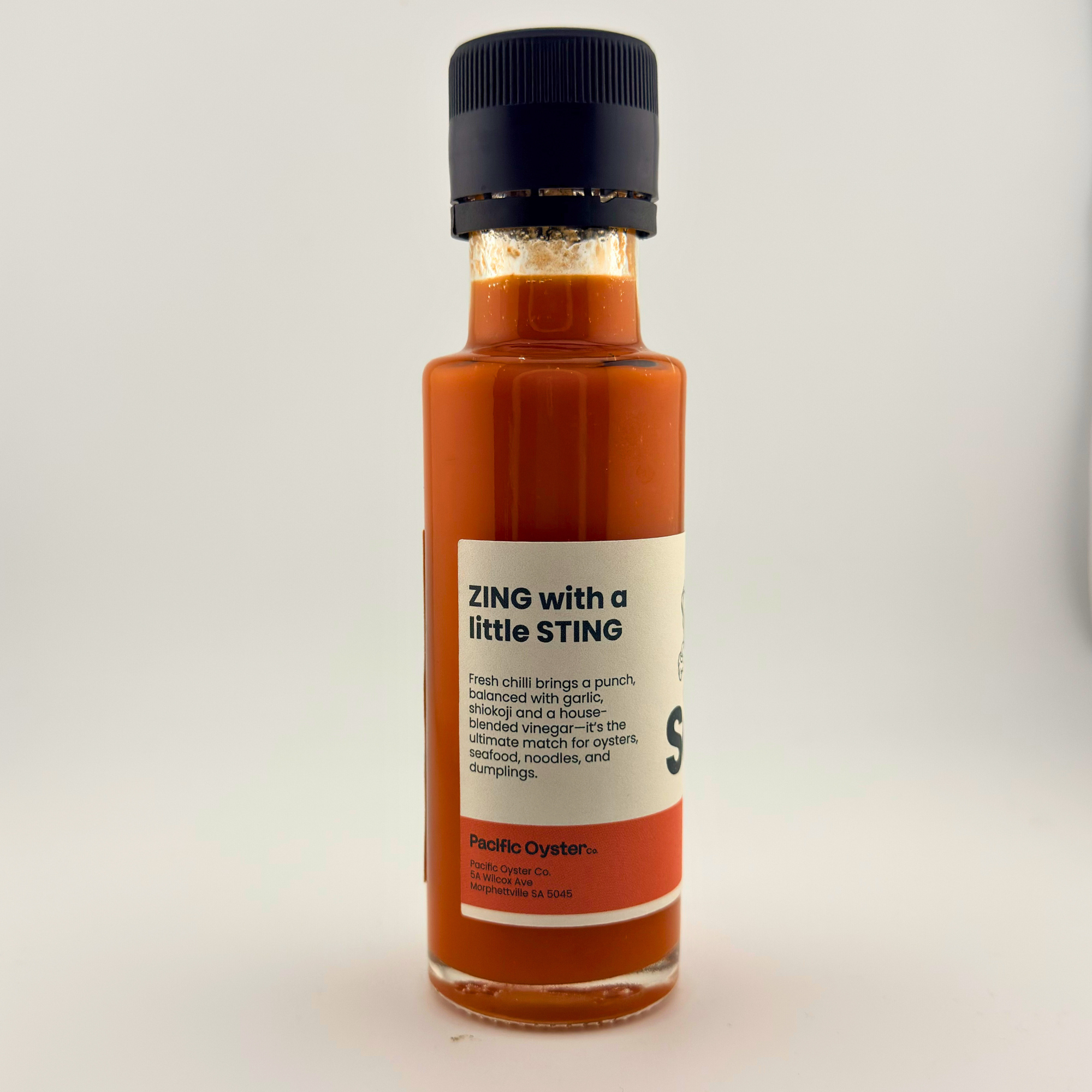 Bottle of hot sauce with a label on a white background
